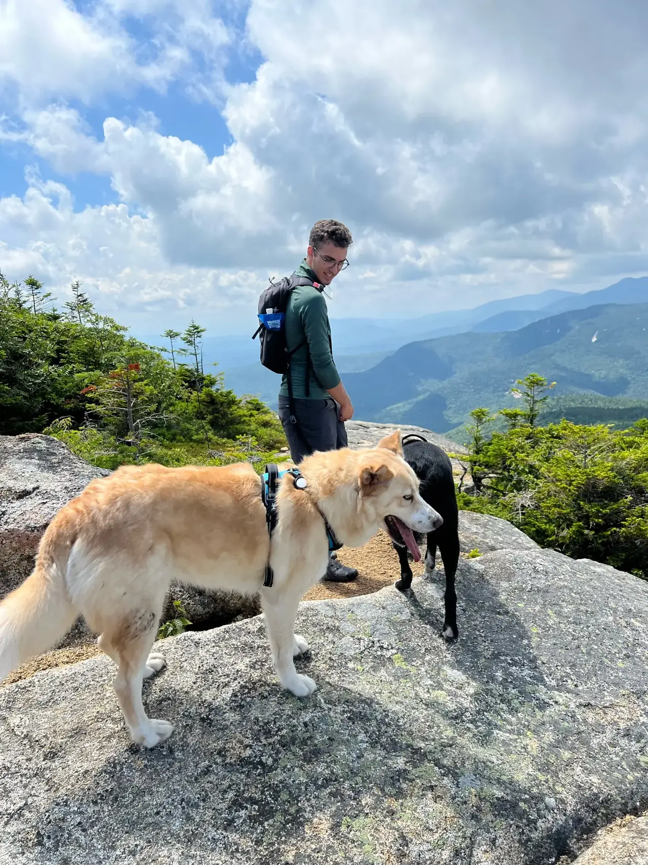 Zach Melendez on Mount Chocorua's summit with two dogs
